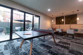 a games room with a ping pong table and a patio at 310 at Nulu Apartments-Student, Louisville Kentucky 